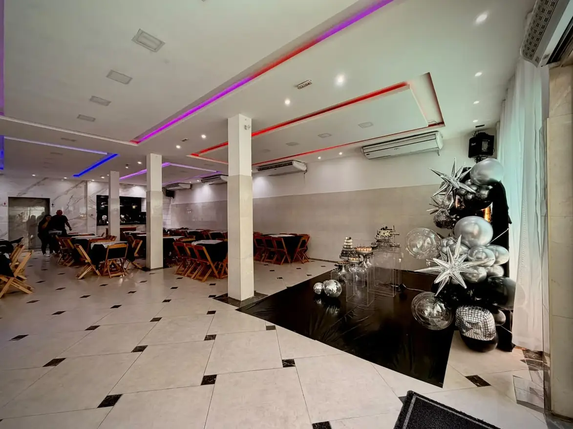 Salão do Espaço Big House decorado com balões prateados e iluminação colorida no forro